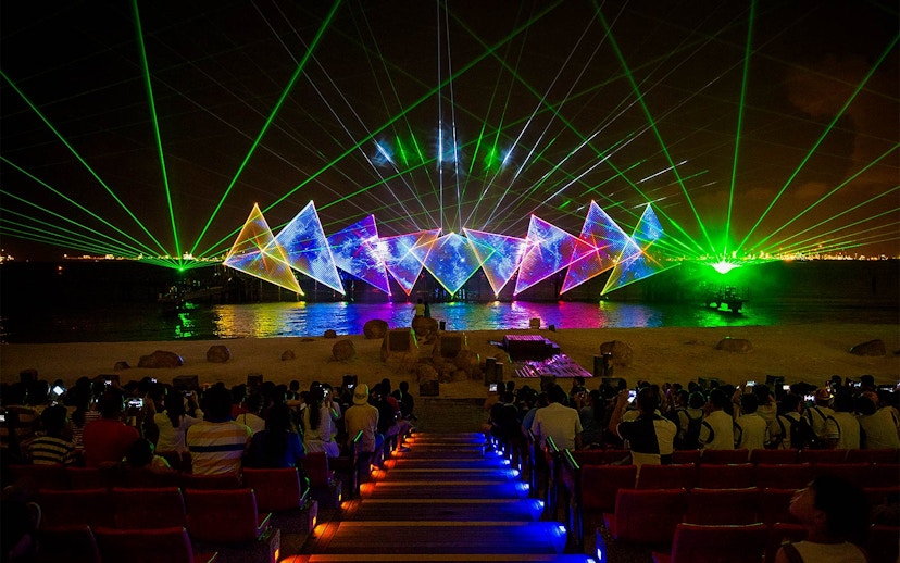Tourists watching the Wings of Time light and sound show at Sentosa Island, Singapore.