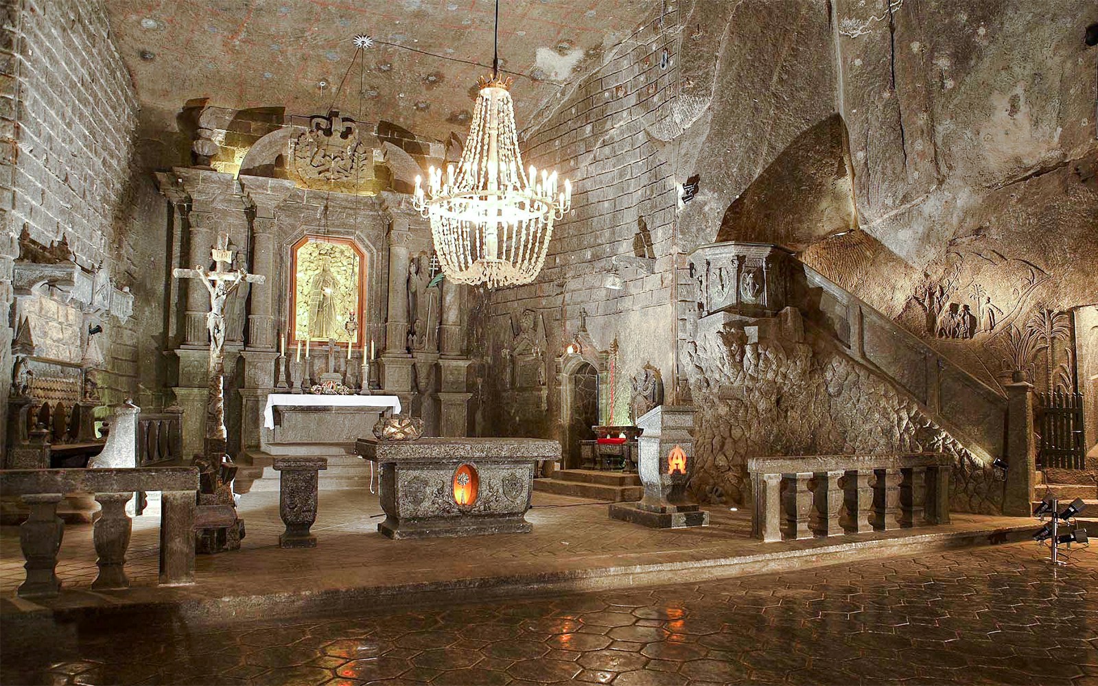 Wieliczka Salt Mine chapel interior with altar, chandelier, and carved salt walls.