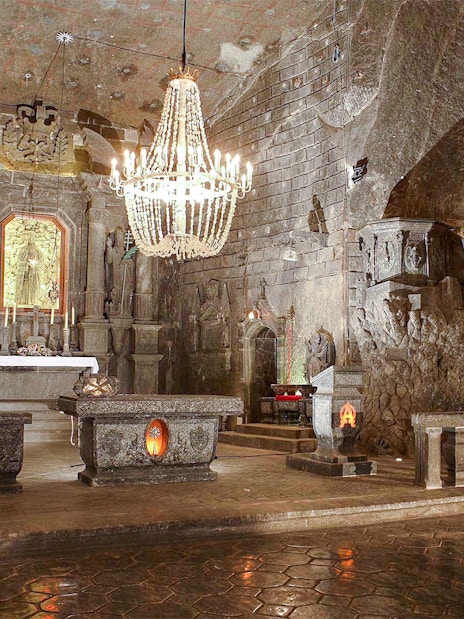 Wieliczka Salt Mine chapel interior with altar, chandelier, and carved salt walls.