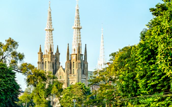 Jakarta Cathedral spires surrounded by lush greenery, part of Jakarta Cultural Journey.