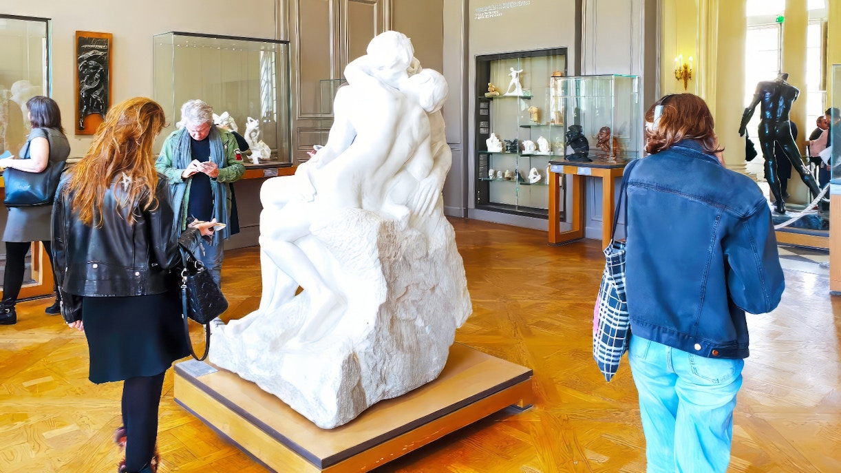 Tourists viewing The Kiss sculpture at the Rodin Museum in Paris.