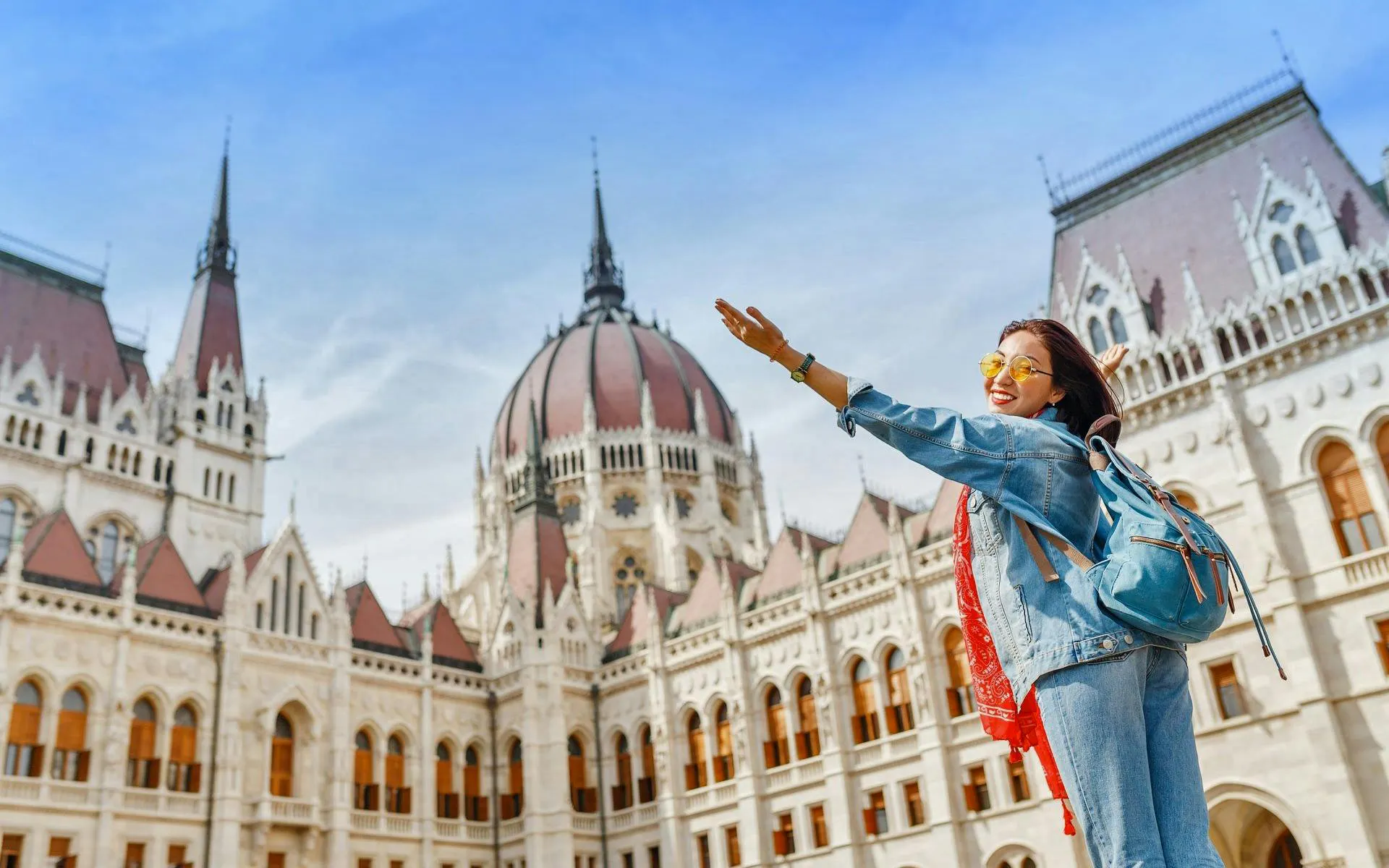 Tourist enjoying view of Budapest Parliament building during Fisherman's Bastion and St Stephen's Basilica tour.