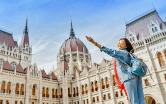 Tourist enjoying view of Budapest Parliament building during Fisherman's Bastion and St Stephen's Basilica tour.