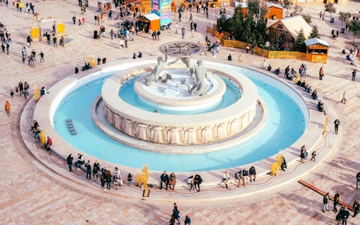 Aerial view of Triton Fountain in Valletta, Malta, with people gathered around.