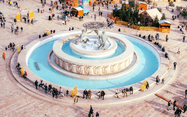 Aerial view of Triton Fountain in Valletta, Malta, with people gathered around.