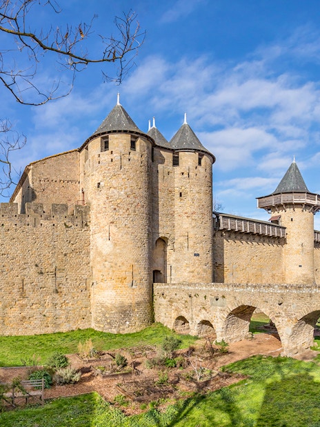 Château Comtal of Carcassonne with stone towers and arched bridge in France.