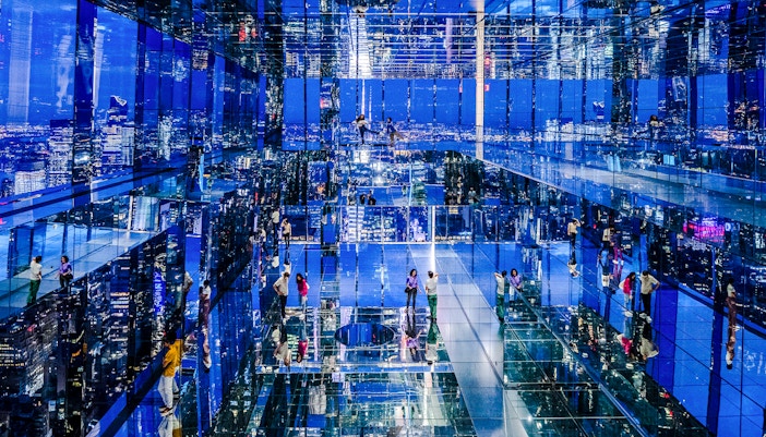 Guests enjoying night views at Summit One Vanderbilt, New York City, with illuminated skyline in the background.