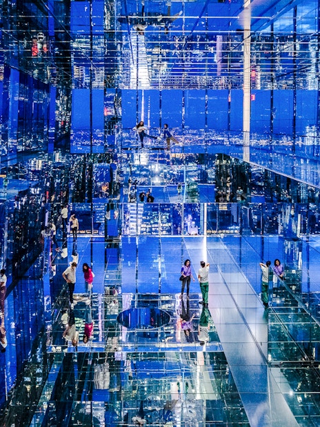 Guests exploring mirrored observation deck at Summit One Vanderbilt, New York City, at night.