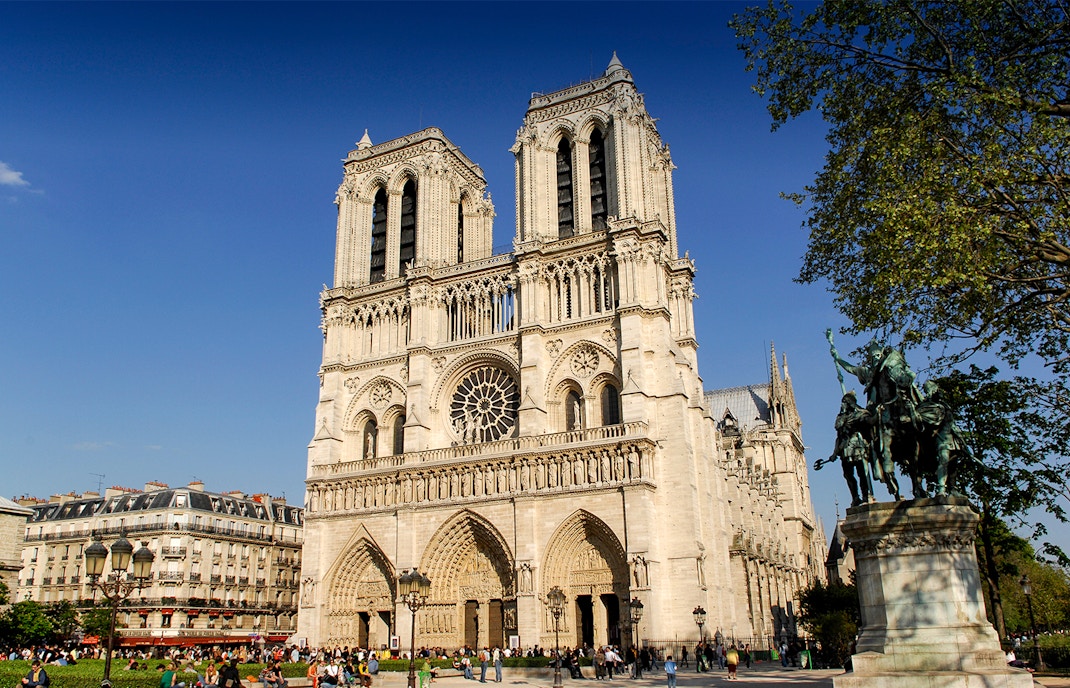 Notre Dame Cathedral facade with tourists in Paris, France.