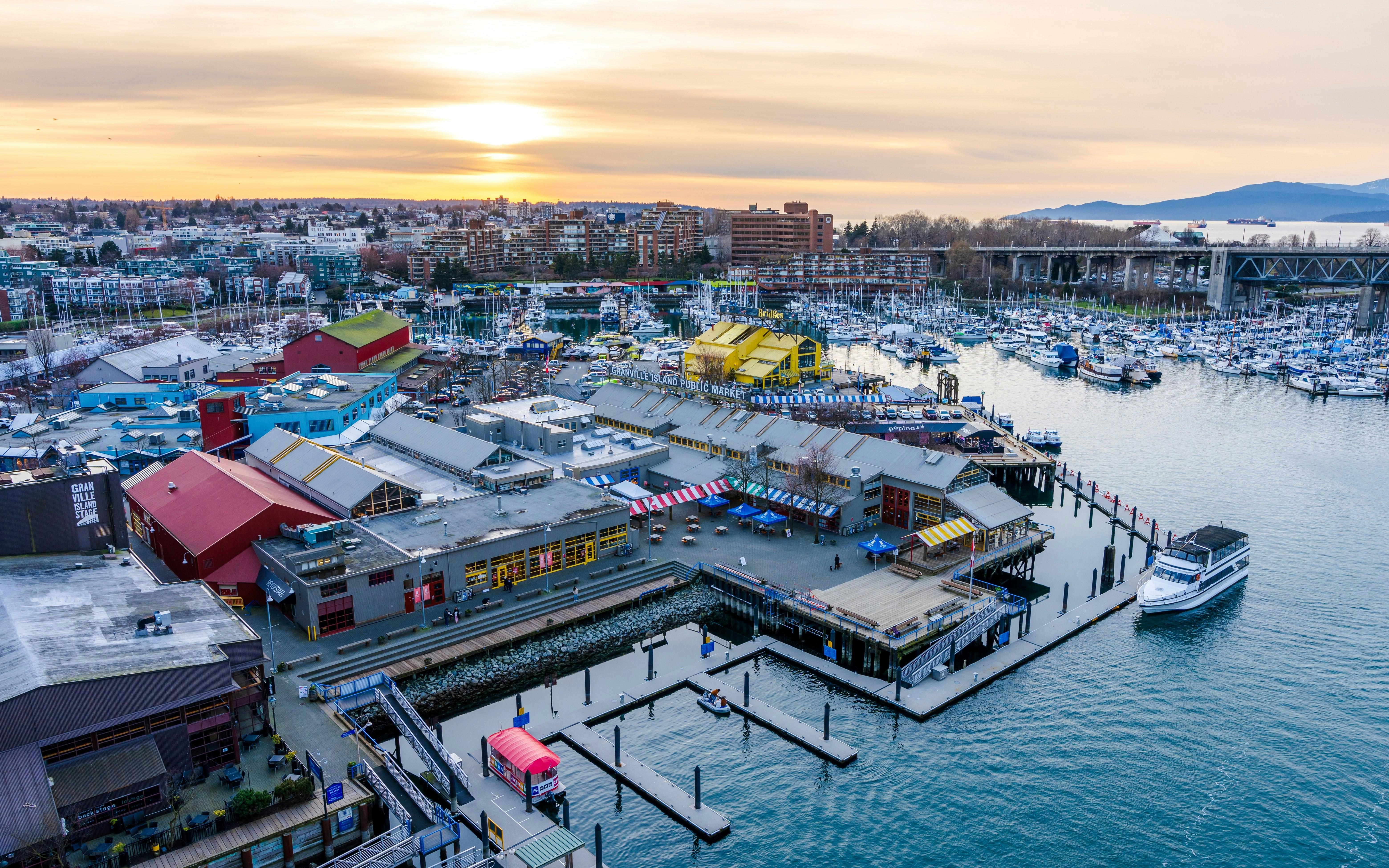 Granville Island Public Market and Marina at dusk with Vancouver skyline in the background, Canada.