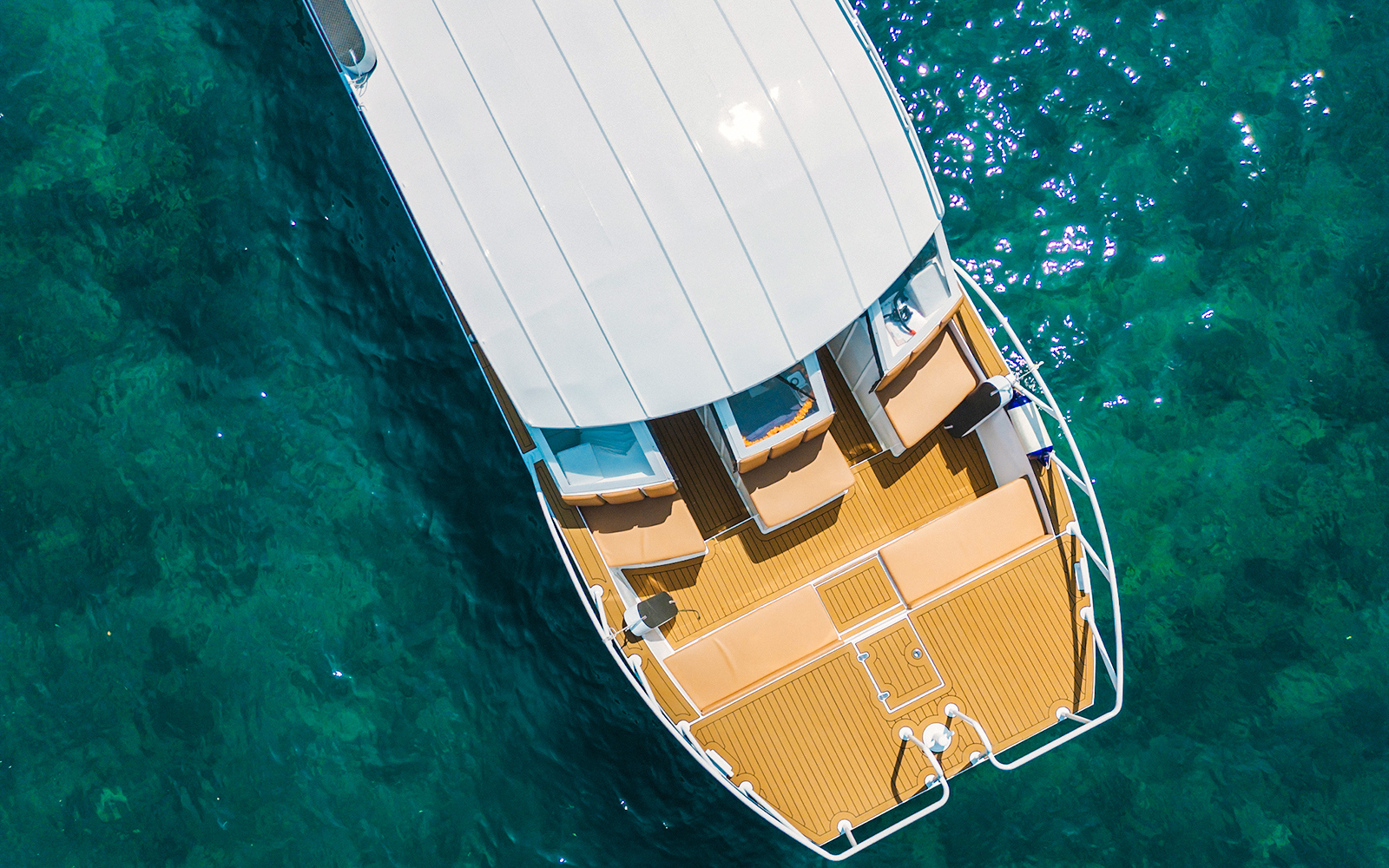 Aerial view of Premium Speed Catamaran deck on clear blue water.