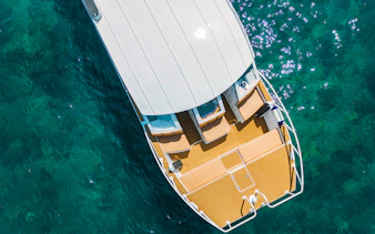 Aerial view of Premium Speed Catamaran deck on clear blue water.