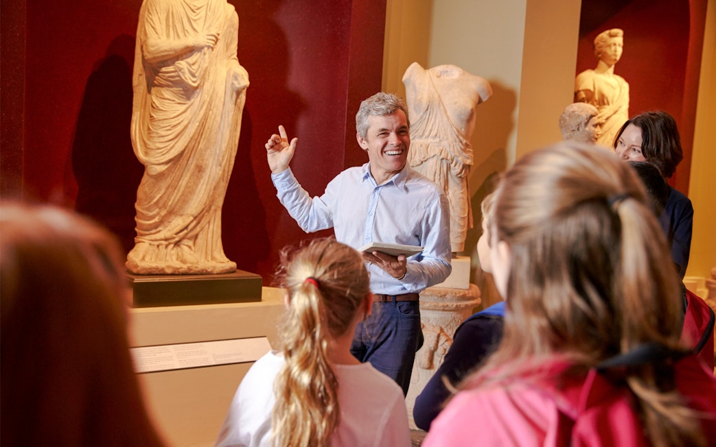 Tour guide explaining sculptures to visitors at the Metropolitan Museum of Art.