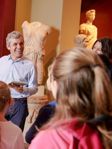 Tour guide explaining sculptures to visitors at the Metropolitan Museum of Art.
