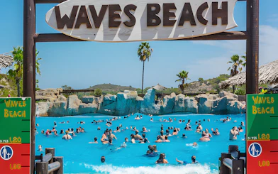 Visitors enjoying the wave pool at Waves Beach in Aquopolis Cullera.