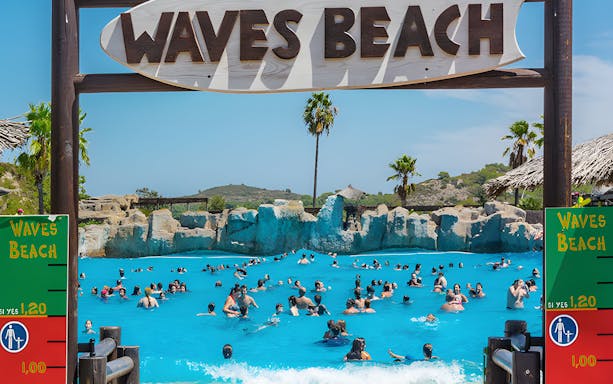 Visitors enjoying the wave pool at Waves Beach in Aquopolis Cullera.