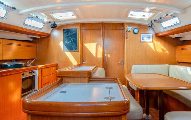 Sailboat interior with dining area and kitchen, La Maddalena Archipelago sailing tour.