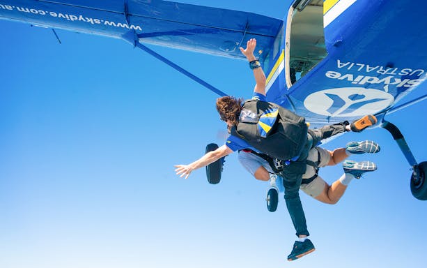 Tandem skydivers jumping from plane over Newcastle.