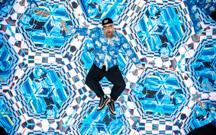 Tourist engaging with kaleidoscopic display at House of Hype interactive experience.