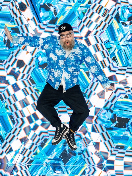 Tourist engaging with kaleidoscopic display at House of Hype interactive experience.