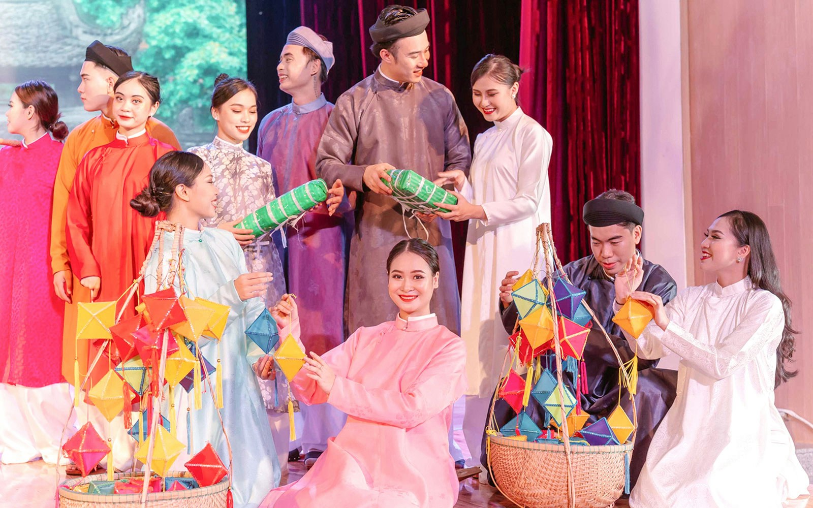 Performers in traditional Ao Dai costumes at a cultural show in Da Nang, holding colorful lanterns.