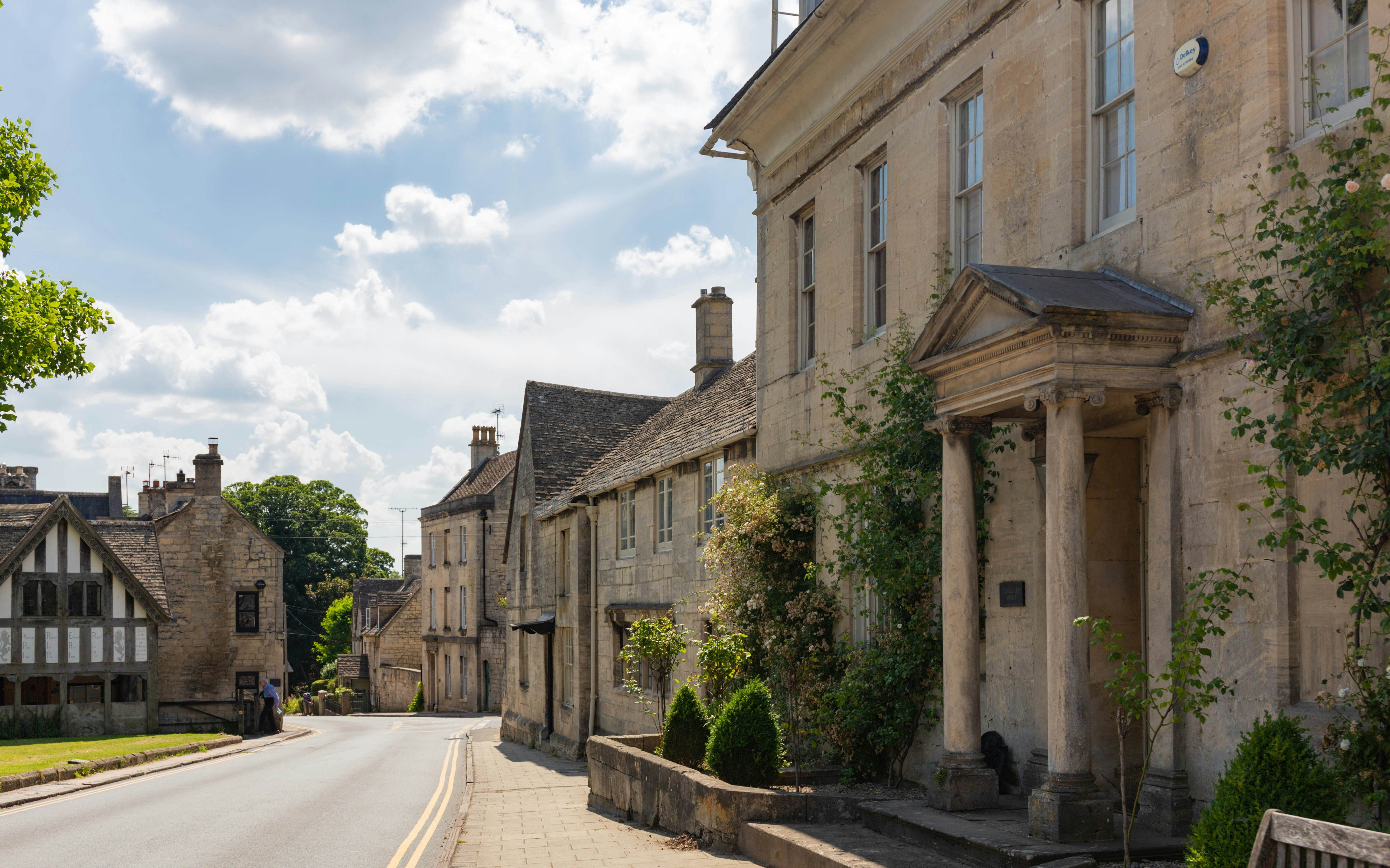 Street view of historic stone buildings in Painswick village, Cotswolds.