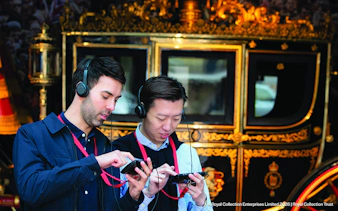 Visitors using audio guides at the Royal Mews, London.