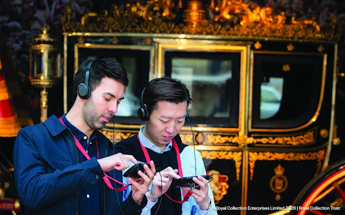 Visitors using audio guides at the Royal Mews, London.