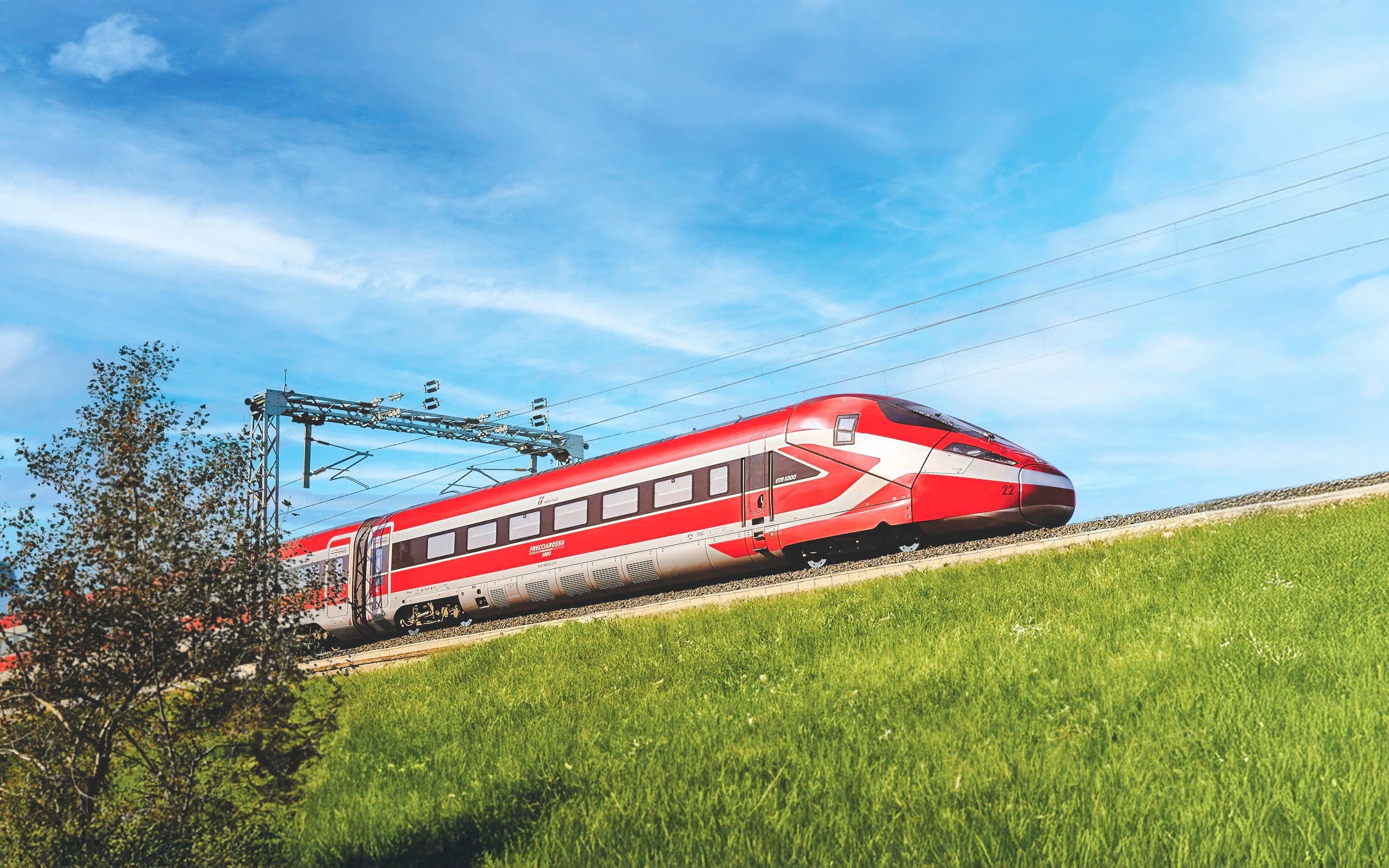 Trenitalia Frecciarossa train traveling through green countryside.