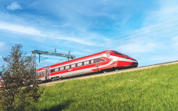 Trenitalia Frecciarossa train traveling through green countryside.