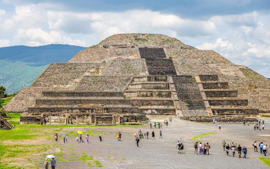 Pyramid of the Moon in Teotihuacan, Mexico, with visitors exploring the site.
