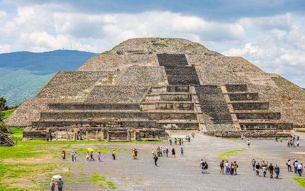 Pyramid of the Moon in Teotihuacan, Mexico, with visitors exploring the site.