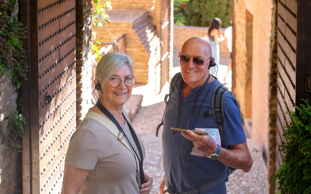 Visitors using audio guides at Montserrat Monastery entrance.