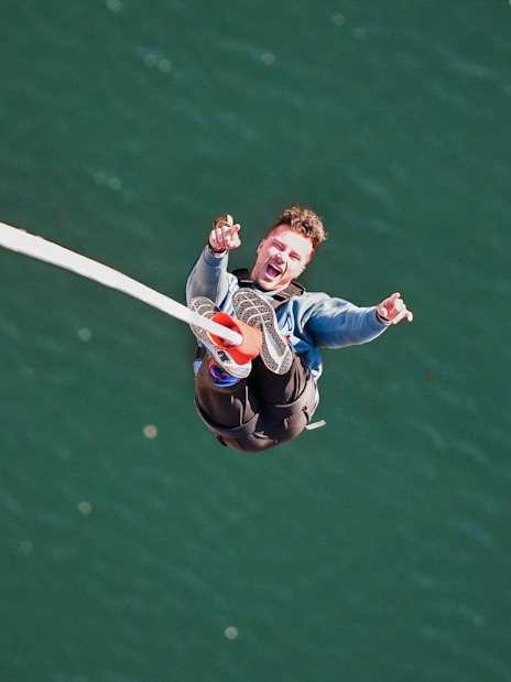 Person bungee jumping over water at Stockhorn, Interlaken.