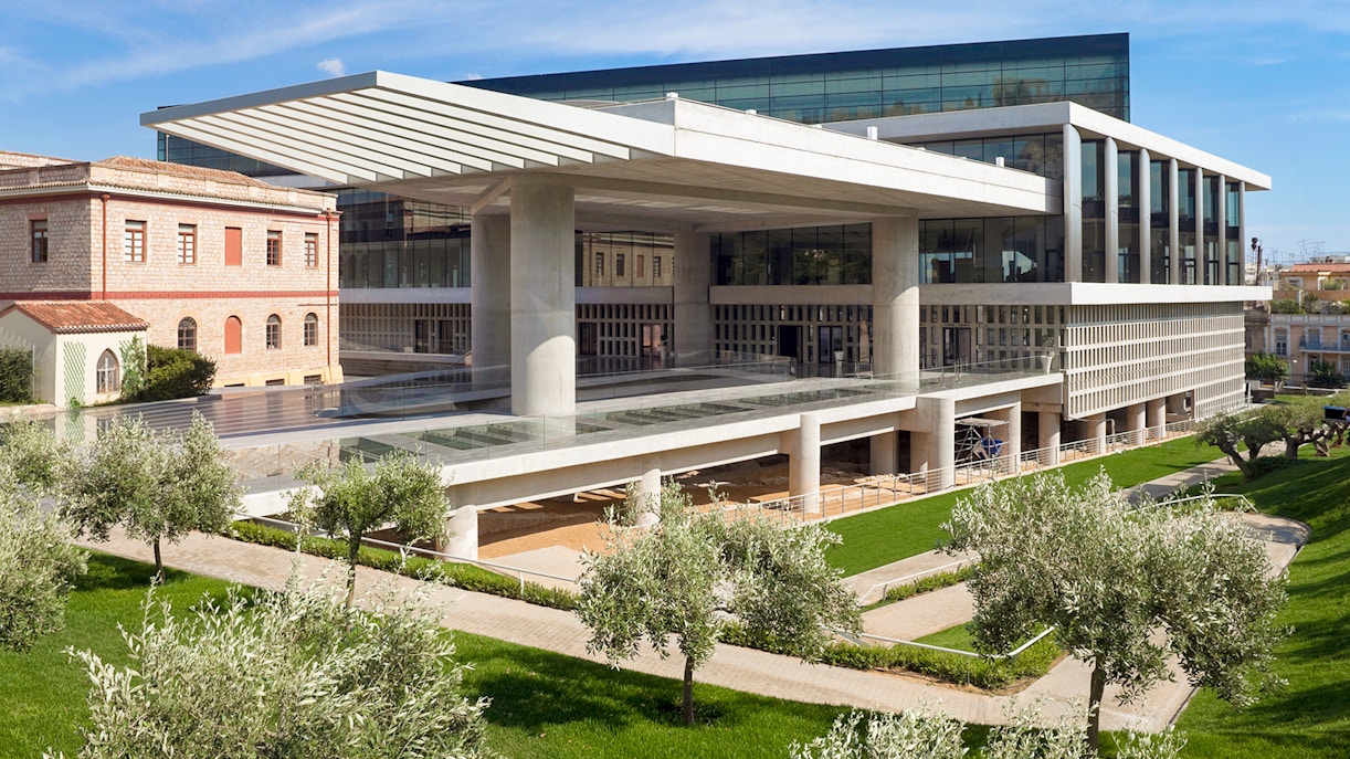 Acropolis Museum exterior with modern architecture and surrounding greenery in Athens, Greece.