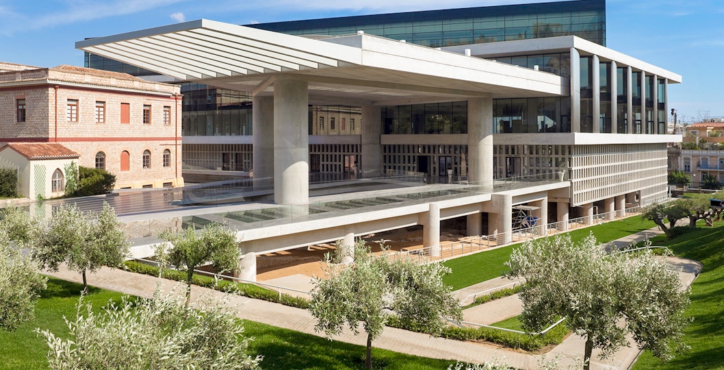 Acropolis Museum exterior with modern architecture and surrounding greenery in Athens, Greece.
