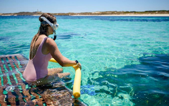 Woman snorkeling in clear waters at Rottnest Island, Australia.