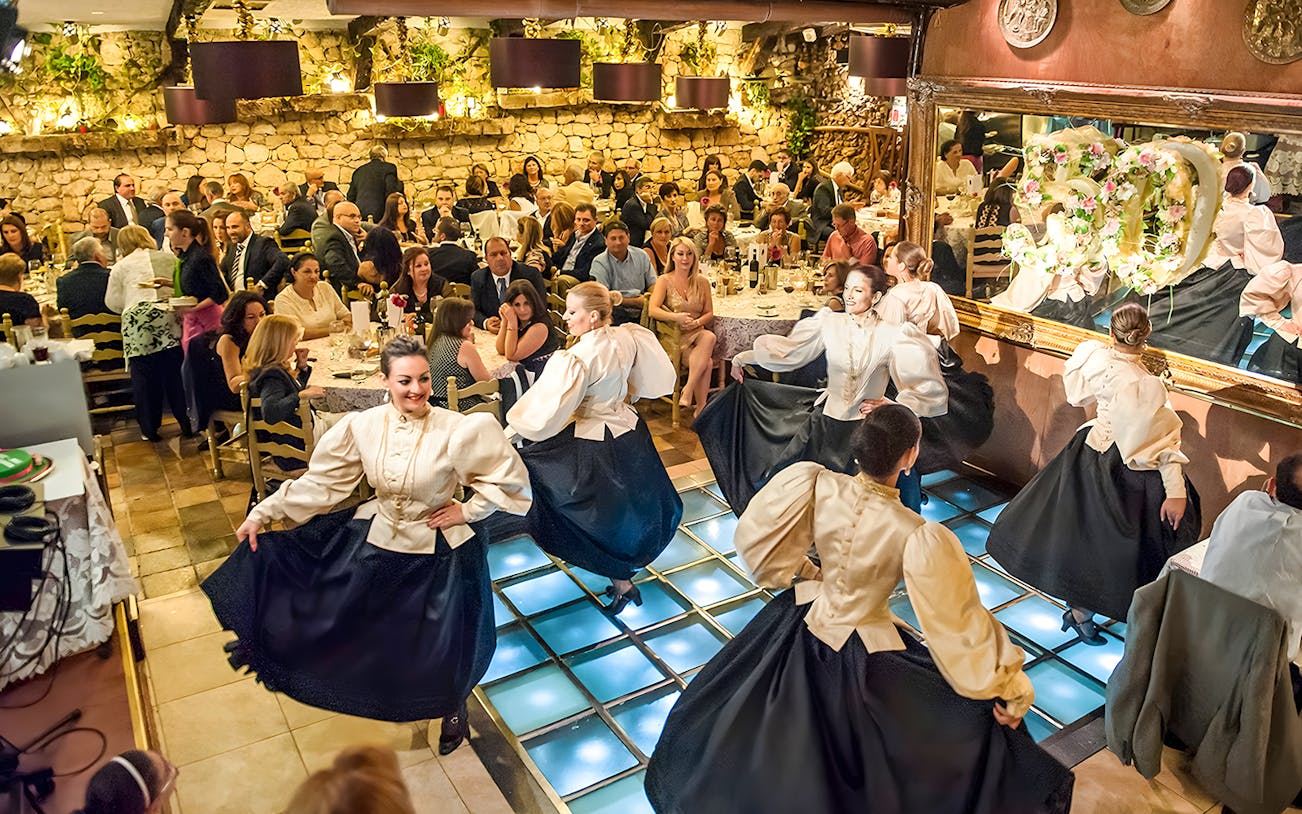 Folklore dancers performing at a traditional Maltese restaurant dinner show.