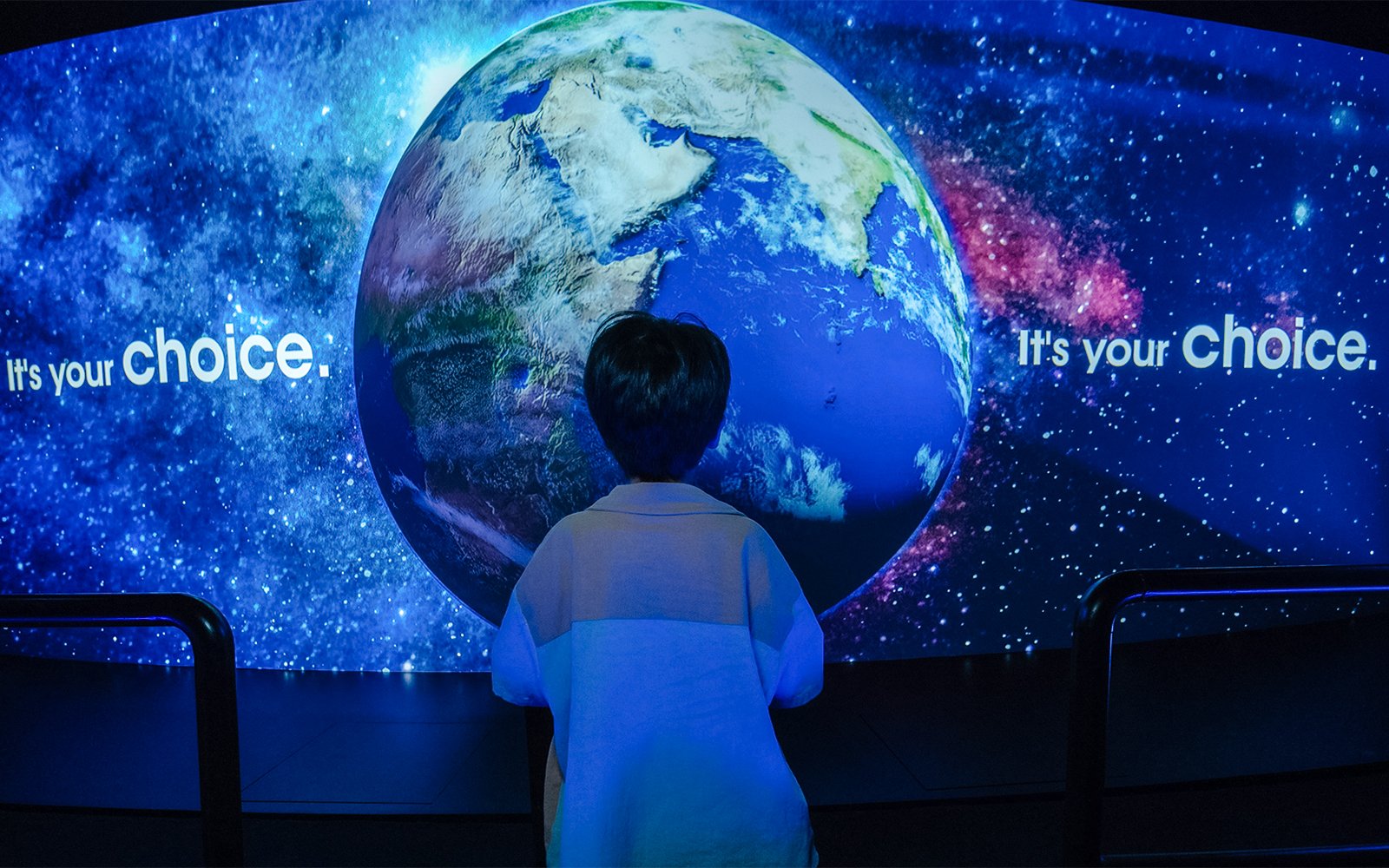 Child viewing interactive globe display at Better World Better Future exhibit.