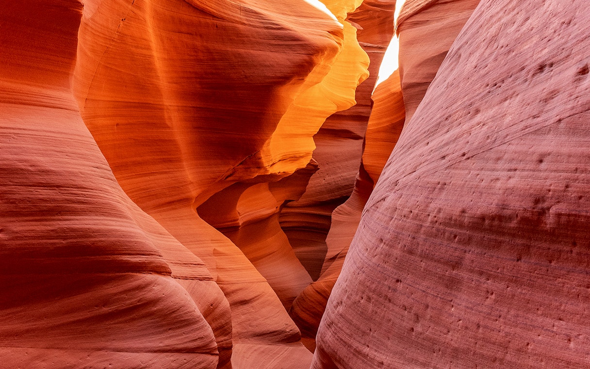 Antelope Canyon X sandstone formations illuminated by sunlight.