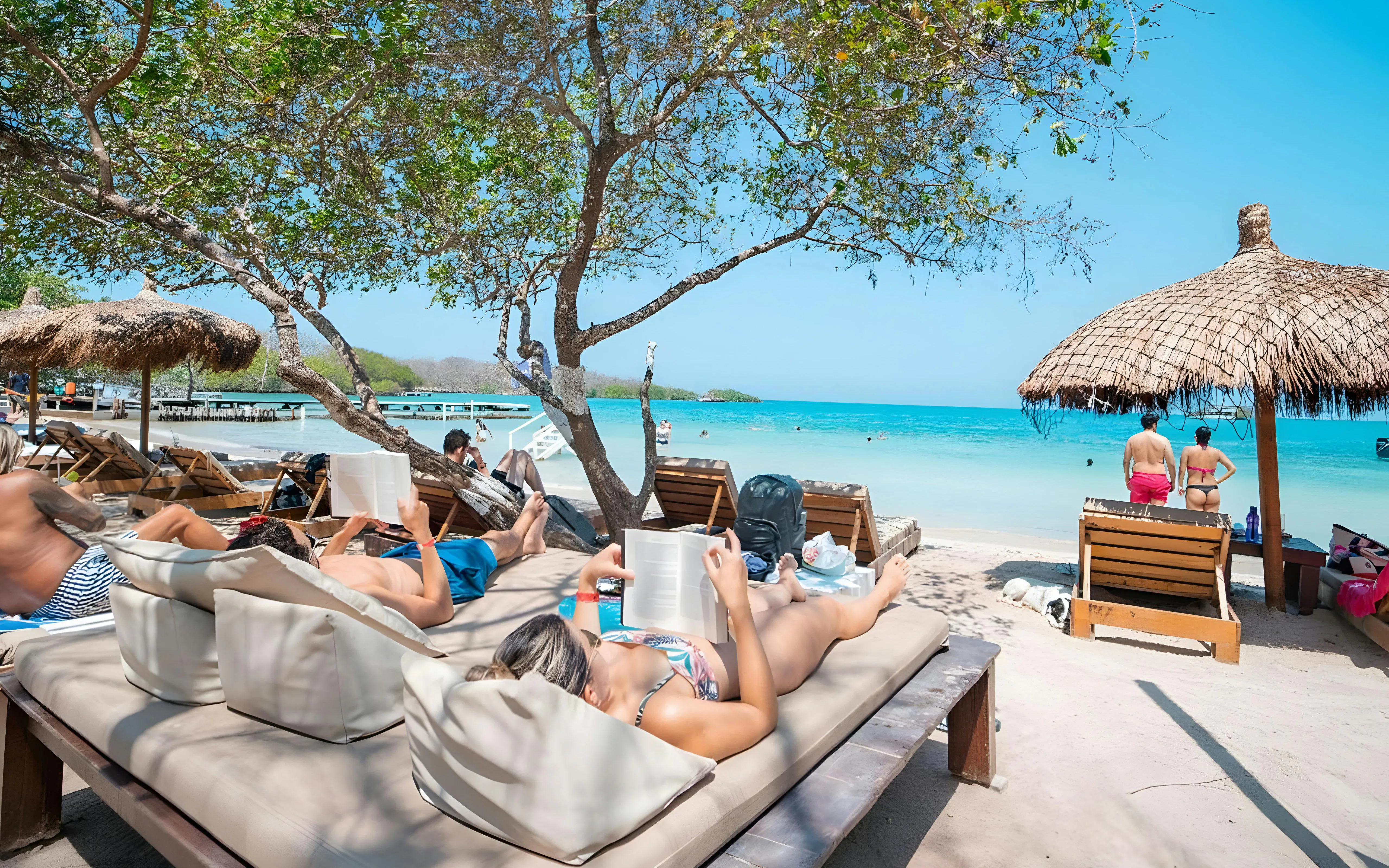 Tourists relaxing on sun loungers at a beach in the Rosario Islands near Cartagena, Colombia.