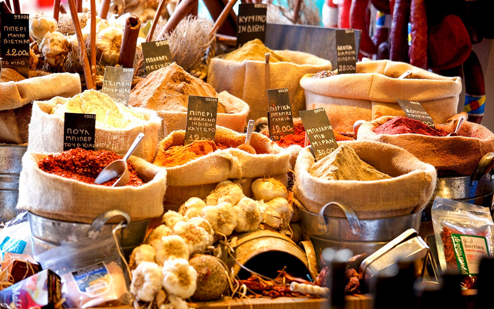 Sacks of colorful spices and garlic at a market stall in Athens during an evening food tasting tour.