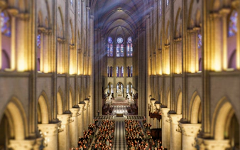 Interior view of Notre-Dame Cathedral with sunlight streaming through stained glass windows.