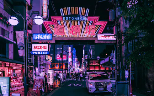 Dotonbori neon signs and bustling street in Osaka at night.