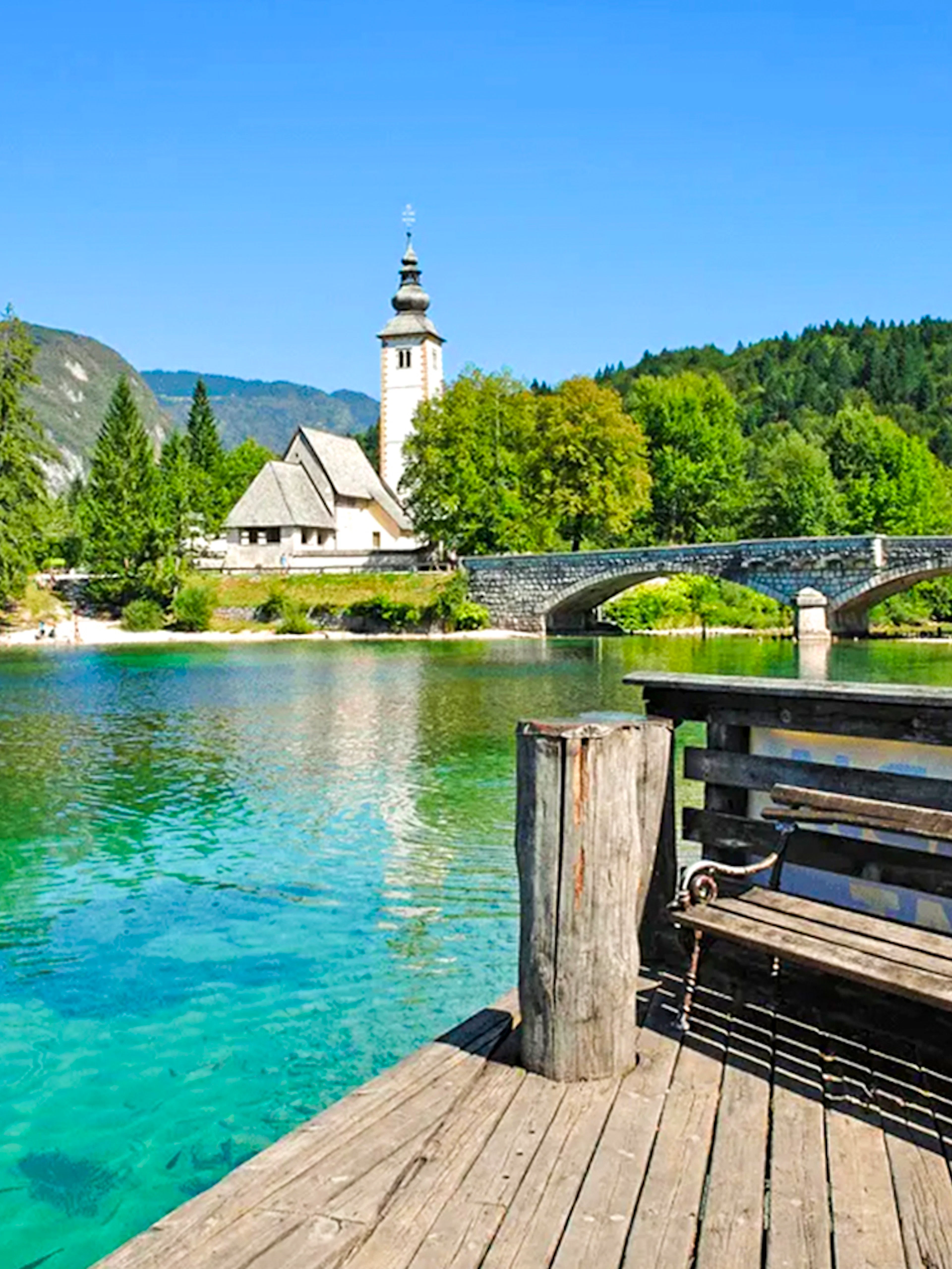 Bohinj Lake with stone bridge and church in Slovenia.