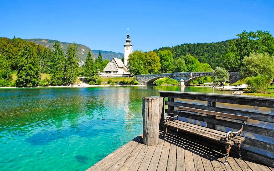 Bohinj Lake with stone bridge and church in Slovenia.