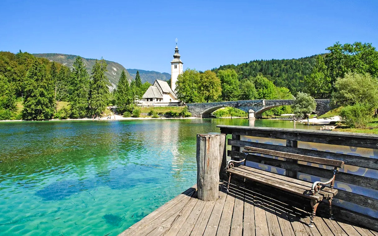 Bohinj Lake with stone bridge and church in Slovenia.