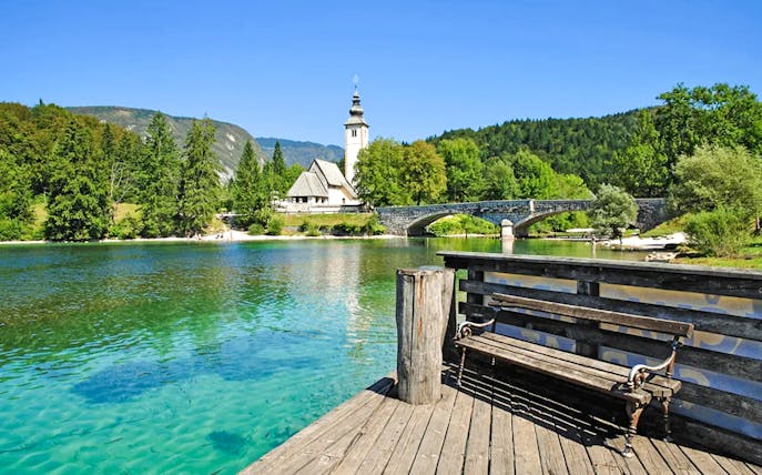 Bohinj Lake with stone bridge and church in Slovenia.