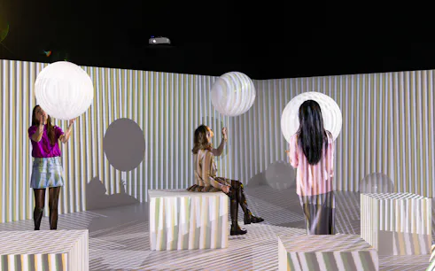 Visitors interact with light installations at Electric Dreams exhibit, Tate Modern.