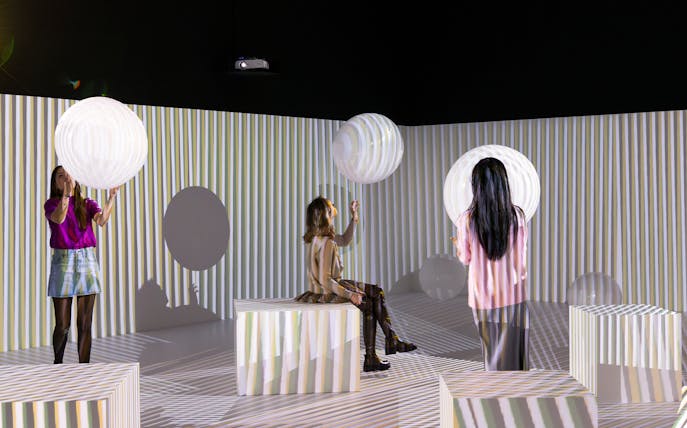 Visitors interact with light installations at Electric Dreams exhibit, Tate Modern.